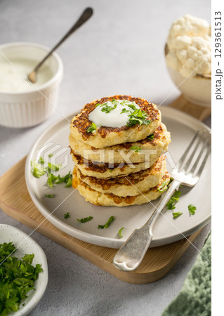 Vegetarian cauliflower pancakes, fritters served with sour cream Vegetarian cauliflower pancakes, fritters served with sour cream 129361513