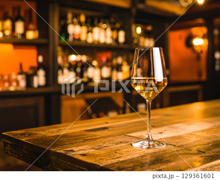 glass of white wine on wooden table 129361601