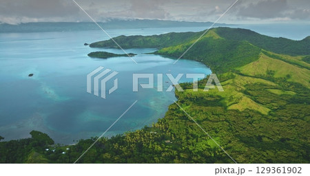 Fiji islands: Aerial view revealing a lush tropical island coastline, turquoise water and vibrant coral reef under cloudy sky. . Wild nature travel landscape. Drone flight Fiji islands: Aerial view revealing a lush tropical island coastline, turquoise water and vibrant coral reef under cloudy sky. . Wild nature travel landscape. Drone flight 129361902
