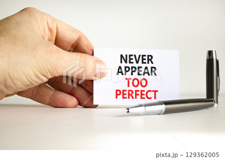 Never appear too perfect symbol. Concept words Never appear too perfect on beautiful white paper. Beautiful white background. Businessman hand. Business never appear too perfect concept. Copy space. 129362005