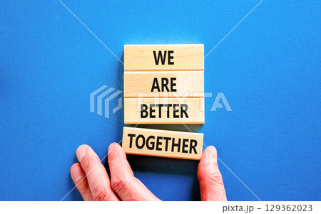 We are better together symbol. Concept words phrase We are better together on beautiful wooden blocks. Beautiful blue background. Businessman hand. Business We are better together concept. Copy space 129362023