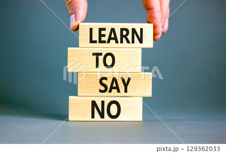Learn to say no symbol. Concept words phrase Learn to say no on beautiful wooden blocks. Beautiful grey paper background. Businessman's hand. Business psychological Learn to say no concept. Copy space 129362033