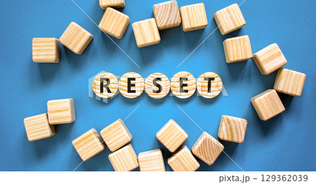 Reset symbol. Concept word Reset on beautiful wooden circles. Beautiful blue table blue background. Beautiful wooden cubes. Business lifestyle reset concept. Copy space. 129362039