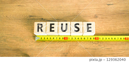 Reuse symbol. Concept word Reuse on beautiful wooden blocks. Beautiful wooden table wooden background. Beautiful yellow ruler. Business lifestyle ecological reuse concept. Copy space. 129362040