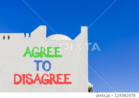 Agree to disagree symbol. Concept words Agree to disagree on beautiful white wall. Beautiful white wall blue sky background. Business and agree to disagree concept. Copy space. Agree to disagree symbol. Concept words Agree to disagree on beautiful white wall. Beautiful white wall blue sky background. Business and agree to disagree concept. Copy space. 129362078