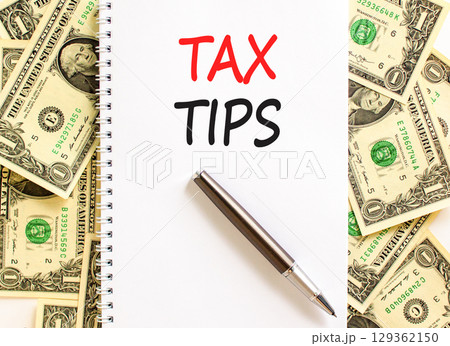 Tax tips symbol. Concept word Tax tips on beautiful white note. Dollar bills. Beautiful dollar bills background. Black pen. Business tax tips concept. Copy space. Tax tips symbol. Concept word Tax tips on beautiful white note. Dollar bills. Beautiful dollar bills background. Black pen. Business tax tips concept. Copy space. 129362150