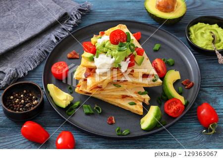 quesadilla with cheese, bacon, avocado on a plate quesadilla with cheese, bacon, avocado on a plate 129363067