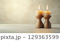Two beige candles in rustic wooden holders create warm ambiance 129363599