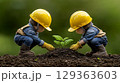 Two child figurines planting sprout in rich soil 129363603