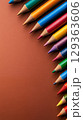 Vibrant colored pencils arranged on brown background 129363606