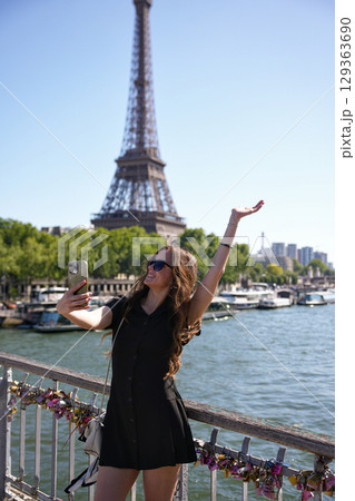 Woman taking selfie with Eiffel Tower in Paris Woman taking selfie with Eiffel Tower in Paris 129363690