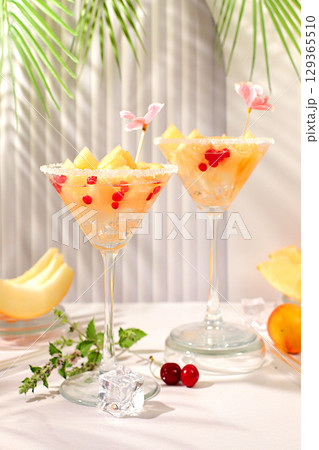 Melon alcoholic cocktail with mint. Martini and royal sangria with melon slices, ice, mint and currants. Summer party concept, advertising for a bar or cafe, detox diet Melon alcoholic cocktail with mint. Martini and royal sangria with melon slices, ice, mint and currants. Summer party concept, advertising for a bar or cafe, detox diet 129365510