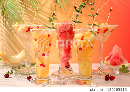 Summer party concept, bar or cafe advertisement. Melon and watermelon alcoholic cocktail with mint. Martini and royal sangria with melon slices, ice, mint and currants, detox diet Summer party concept, bar or cafe advertisement. Melon and watermelon alcoholic cocktail with mint. Martini and royal sangria with melon slices, ice, mint and currants, detox diet 129365516