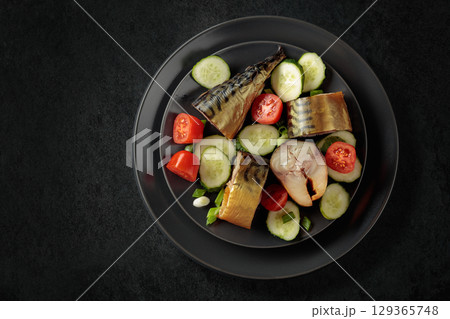 Smoked mackerel with fresh cucumbers, tomatoes and green onion. 129365748
