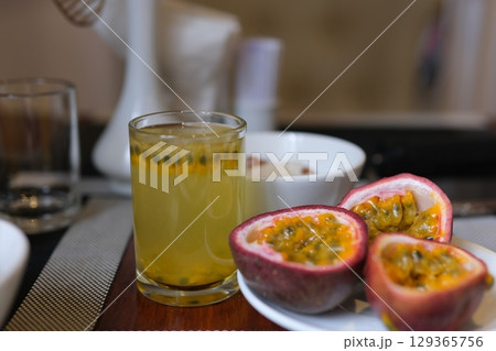 passion fruit juice sliced exotic organic fresh passion fruit with flowing dripping fresh water drops isolated on warm colorful background 129365756