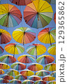 Many rainbow colored umbrellas against blue sky 129365862