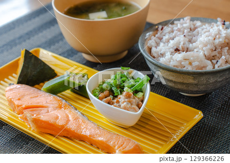 焼き鮭と納豆、雑穀ご飯が並ぶ健康的な和風朝食 129366226