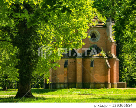 Historic church in a picturesque park under a clear blue sky 129366654