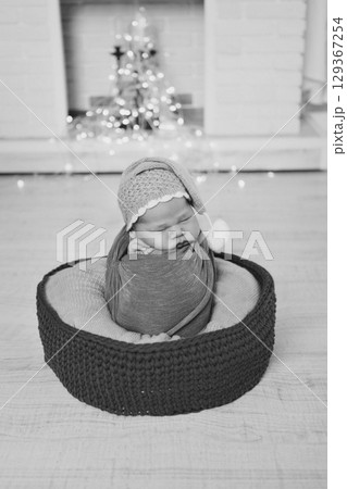 A newborn baby is wrapped in diapers with a wool cap in a basket. Swaddling, maternity hospital, family, ivf, life planning, parenting. A mother's love for her child. Baby food. High quality photo A newborn baby is wrapped in diapers with a wool cap in a basket. Swaddling, maternity hospital, family, ivf, life planning, parenting. A mother's love for her child. Baby food. High quality photo 129367254