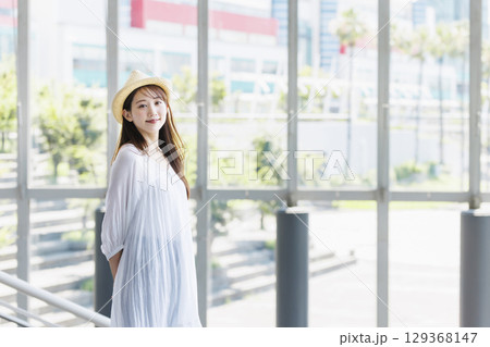 麦わら帽子をかぶって観光を楽しむ若い女性 129368147