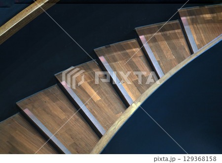 Layered wood spiral stairs with railings handle grip interior. 129368158
