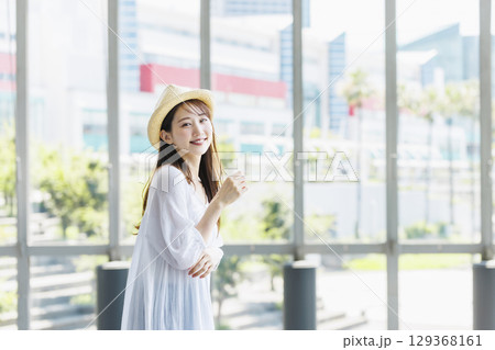 麦わら帽子をかぶって観光を楽しむ若い女性 129368161