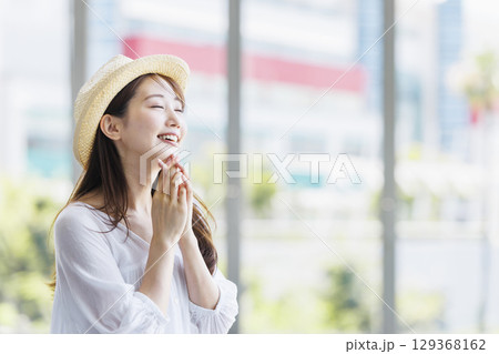 麦わら帽子をかぶって観光を楽しむ若い女性 129368162