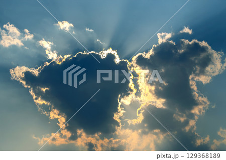 Dramatic cloudy sky with golden sunlight breaking through at sunset Dramatic cloudy sky with golden sunlight breaking through at sunset 129368189