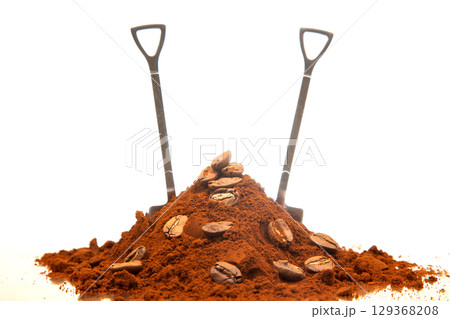 A rustic composition featuring two shovels in a heap of ground coffee with coffee beans A rustic composition featuring two shovels in a heap of ground coffee with coffee beans 129368208