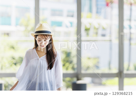 麦わら帽子をかぶって観光を楽しむ若い女性 129368215