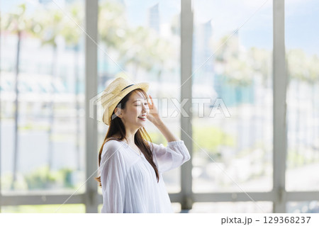 麦わら帽子をかぶって観光を楽しむ若い女性 129368237