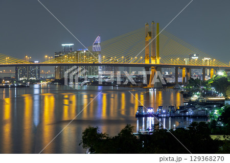 Scenery view after sunset of Thotsamarachan Bridge (Rama IX Bridge) crossing Chao phraya river. 129368270