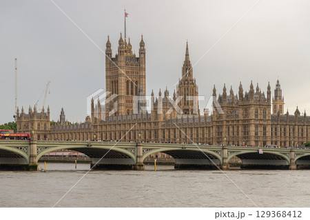 Palace of Westminster (the Houses of Parliament) with the Westminster Bridge spanning the river thames in the foreground. 129368412