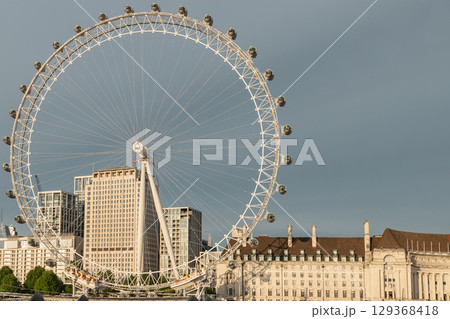 the London Eye or the iconic observation wheel, showcasing its distinctive white structure and numerous enclosed capsules around its circumference. 129368418