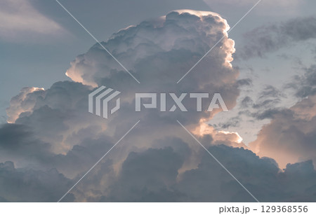 The sky is being covered with fluffy white clouds. 129368556