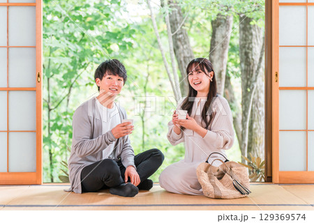 国内旅行で温泉旅館・和室に宿泊して庭の景色を眺める夫婦・カップル 国内旅行で温泉旅館・和室に宿泊して庭の景色を眺める夫婦・カップル 129369574