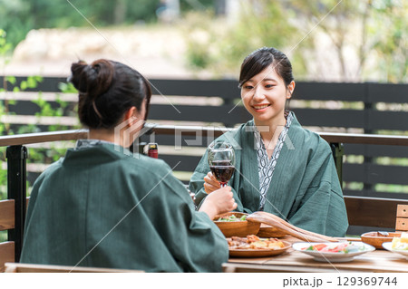 バルコニー・ウッドデッキで食事する旅館・温泉旅館に女子旅に来た若いアジア人女性（旅行・トラベル） 129369744