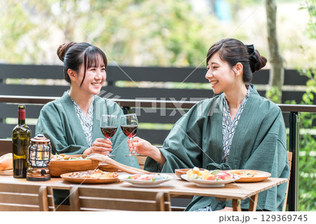 バルコニー・ウッドデッキで食事する旅館・温泉旅館に女子旅に来た若いアジア人女性（旅行・トラベル） 129369745