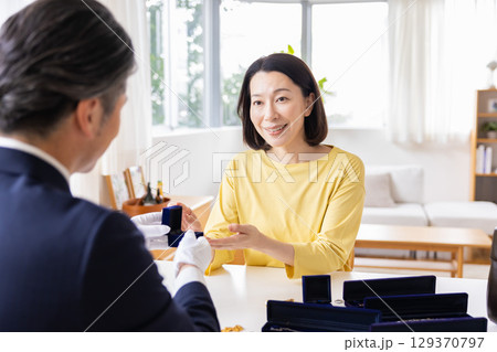 出張買取 自宅で査定をしてもらっている主婦 出張買取 自宅で査定をしてもらっている主婦 129370797