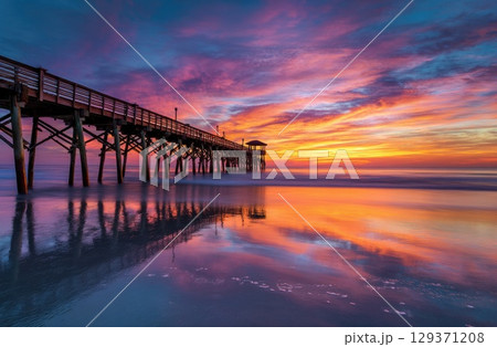 colorful sunrise over the beach with a pier. colorful sunrise over the beach with a pier. 129371208