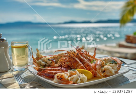 plate of fresh, grilled seafood with prawns and lobster on the beach in sunny Caribbean island plate of fresh, grilled seafood with prawns and lobster on the beach in sunny Caribbean island 129371287