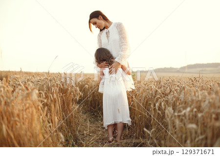 Family in a summer field. Sensual photo. Cute little girl. Woman in a white dress. Family in a summer field. Sensual photo. Cute little girl. Woman in a white dress. 129371671