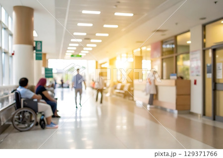Busy hospital corridor with patients, staff, and natural light creating a warm atmosphere 129371766