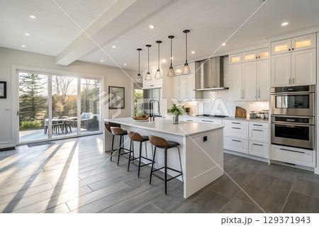 Modern Bright Kitchen Interior with Large Island, Stylish Bar Stools, and Natural Light 129371943