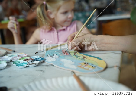 A young mother and her daughter enjoy a creative art session at home  129373728