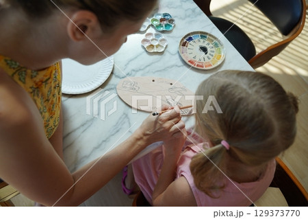 A young mother and her daughter enjoy a creative art session at home  129373770