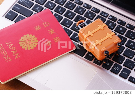 パスポートとスーツケース - 海外旅行のためにスーツケースとパスポートを用意する パスポートとスーツケース - 海外旅行のためにスーツケースとパスポートを用意する 129373808