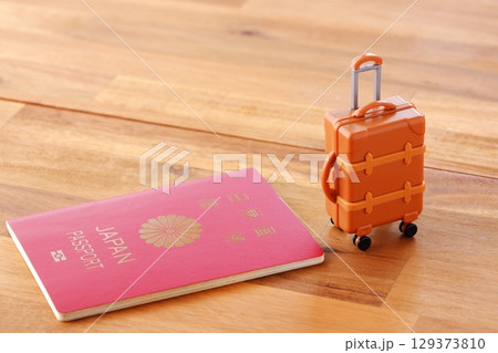 パスポートとスーツケース - 海外旅行のためにスーツケースとパスポートを用意する パスポートとスーツケース - 海外旅行のためにスーツケースとパスポートを用意する 129373810