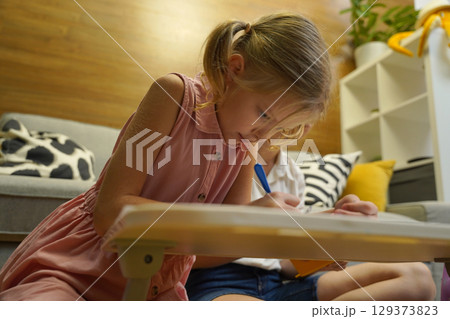 A mother supports her daughter with homework 129373823