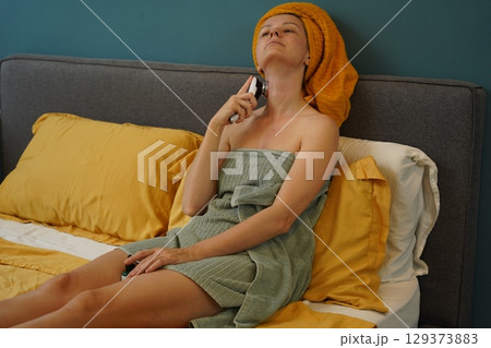 Young woman using infrared massager Young woman using infrared massager 129373883